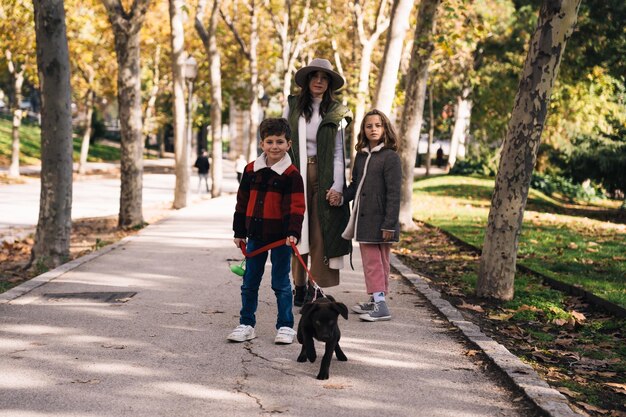 Mãe e filhos com cães no beco do parque