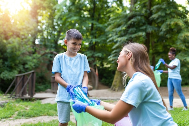 Mãe e filhos estão pegando o lixo para limpar a floresta