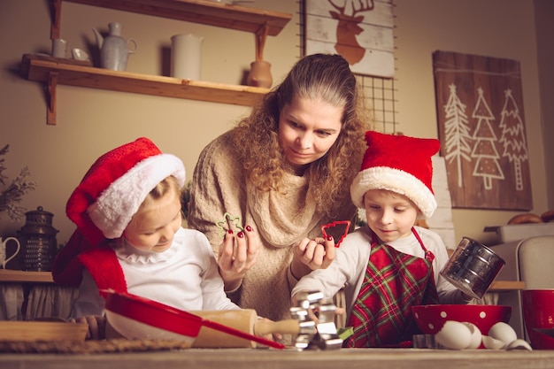 Mãe e filhos estão preparando biscoitos na cozinha