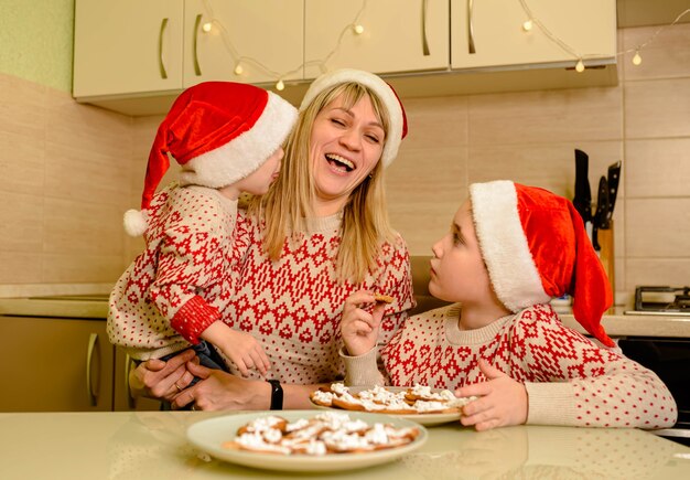 Mãe e filhos fazendo biscoitos de gengibre para o Natal