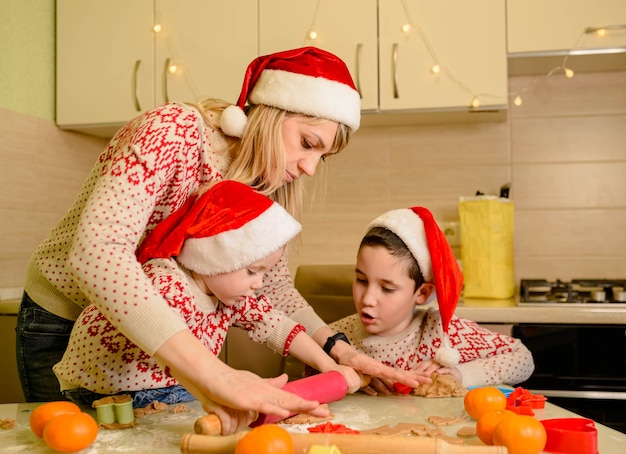 Mãe e filhos fazendo biscoitos de gengibre para o Natal