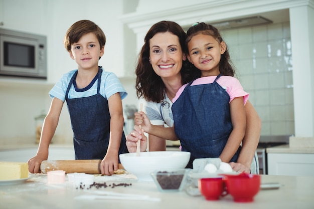 Mãe e filhos misturando a massa enquanto prepara biscoitos