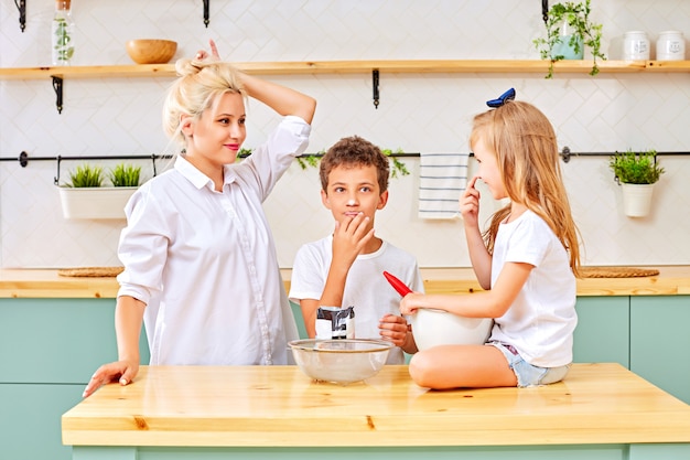 Mãe e filhos preparando pastelaria na cozinha