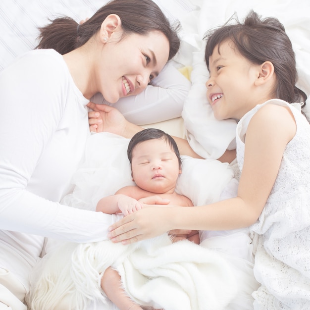 Mãe e filhos recém-nascidos e irmã mais velha. família feliz.