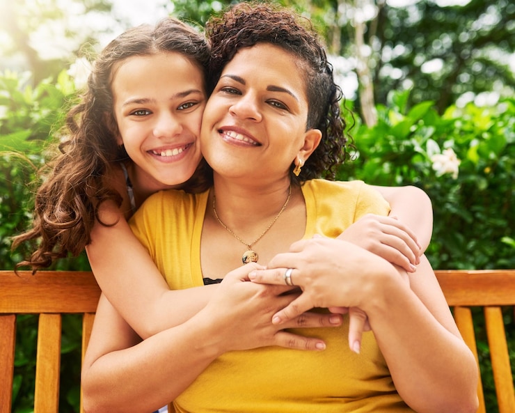 Foto mãe e menina ao ar livre em retrato com conexão de abraço e ligação juntos no dia das mães no parque pessoas felizes mãe e criança adolescente com amor abraçam por gratidão afeição ou apoio no banco