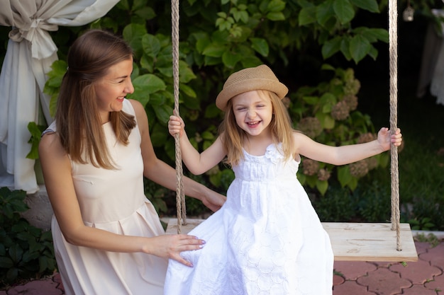 Mãe e menina bonitinha no belo jardim