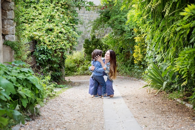 Mãe e menino bonito andando ao ar livre no antigo parque da cidade