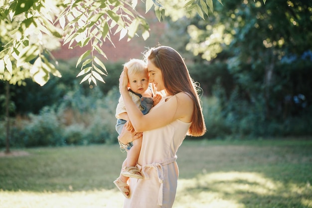 Mãe e menino de pé perto de uma árvore no parque