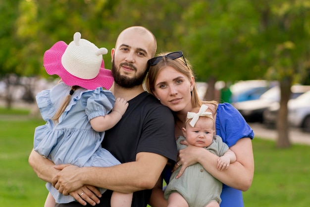 Mãe e pai segurando crianças nas mãos e caminhando no parque ao ar livre