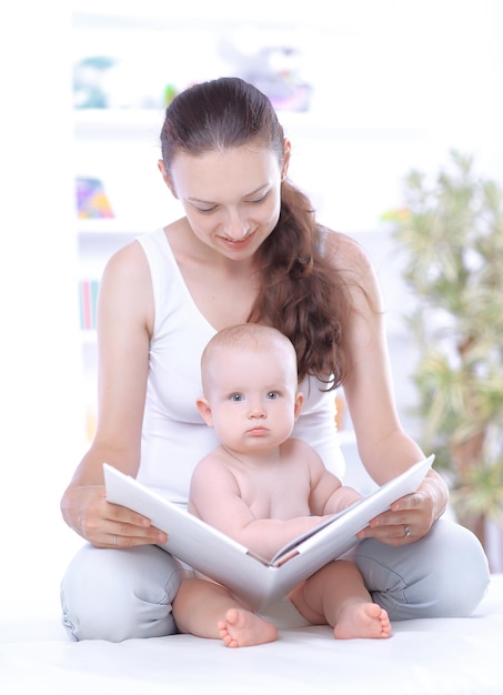 Mãe encantadora lendo um livro para o bebê