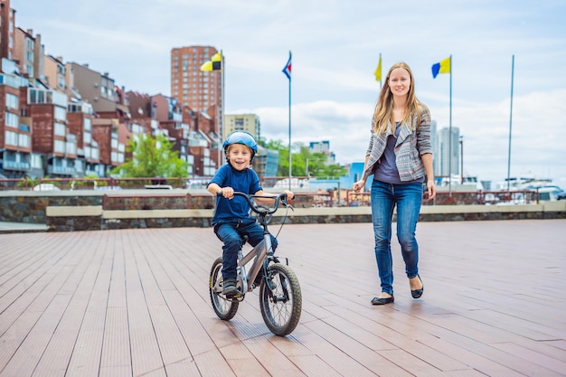 Mãe ensina filho a andar de bicicleta no parque