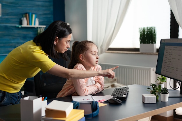 Mãe ensinando a pequena aluna sobre lição escolar em casa