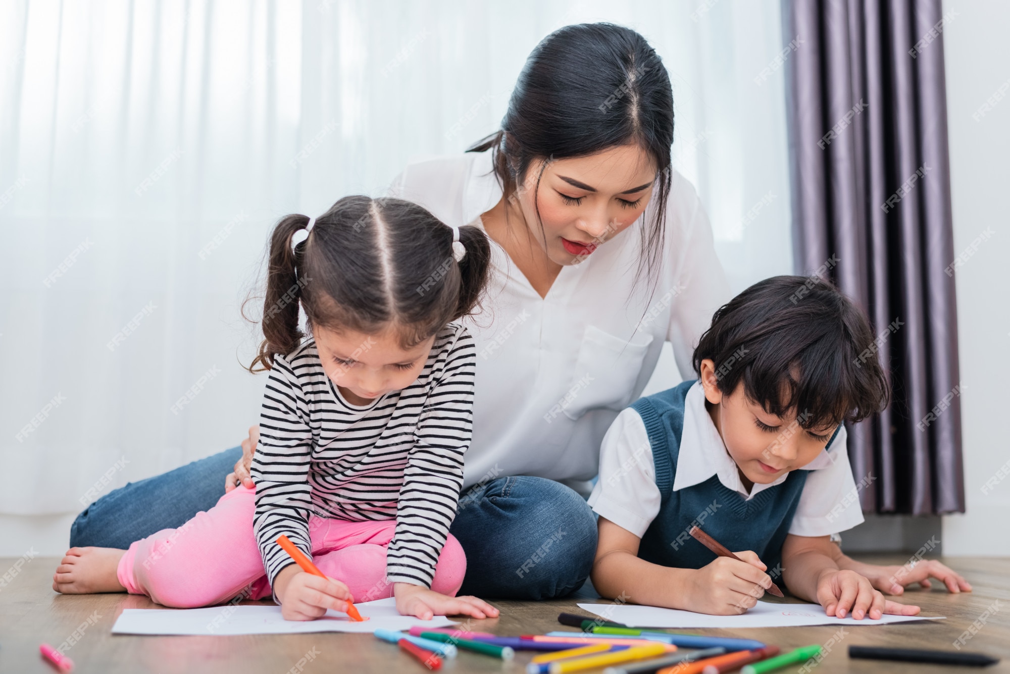 Mãe ensinando crianças na aula de desenho. Filha e filho pintando