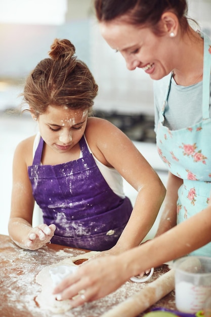 Mãe ensinando ou filho assando com massa na cozinha para o desenvolvimento da criança para preparar biscoitos na casa da família menina desordenada mãe feliz ou aprendendo receita de pastelaria para vincular lanches de cozinha ou sobremesa