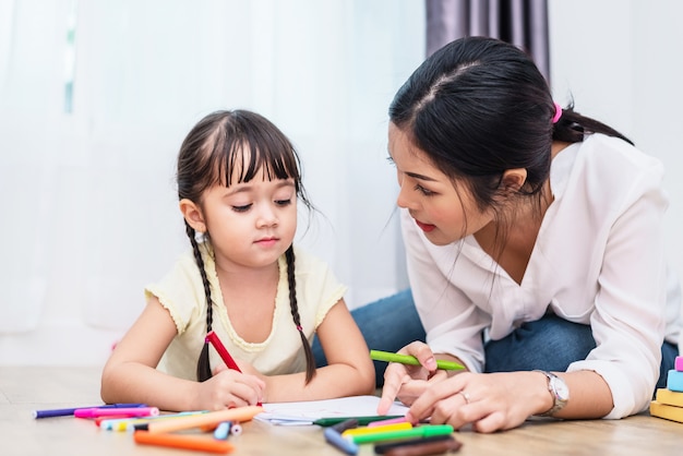 Mãe ensinando crianças na aula de desenho. Filha e filho pintando