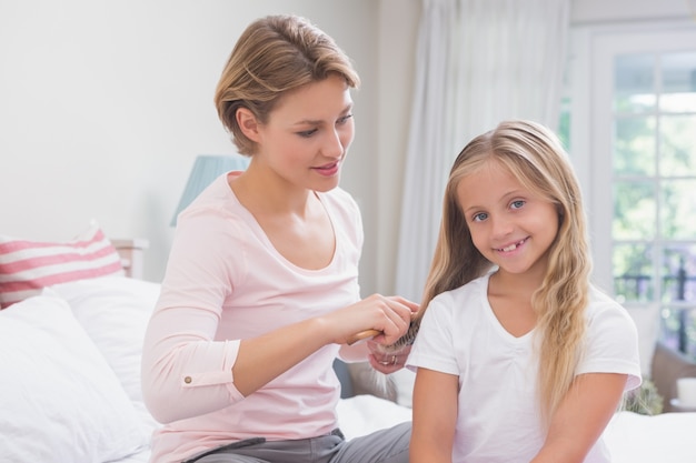 Mãe escovando o cabelo de suas filhas