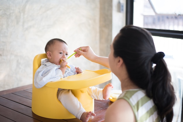 Mãe está alimentando comida para bebé.