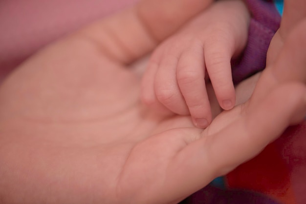 mãe está brincando com bebê recém-nascido em casa