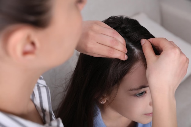 Mãe examinando o cabelo de sua filha dentro de casa Tratamento anti-piolhos