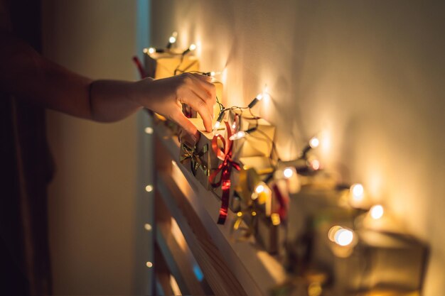 Foto mãe faz um calendário do advento para uma criança um filho ou filha na cabeceira