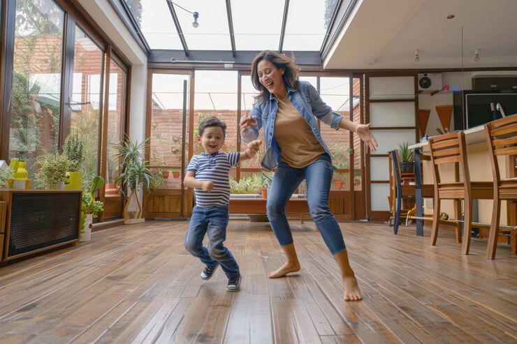 Mãe feliz a divertir-se a dançar com o filho em casa Mãe latino-americana feliz a divertirse a dançar