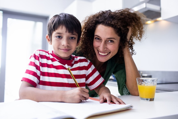 Mãe feliz, ajudando o filho com a lição de casa