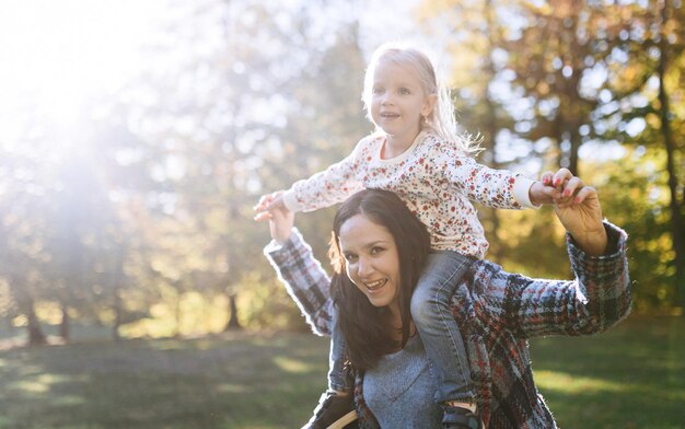 Mãe feliz com filha no parque outono recreação ao ar livre mãe e filha