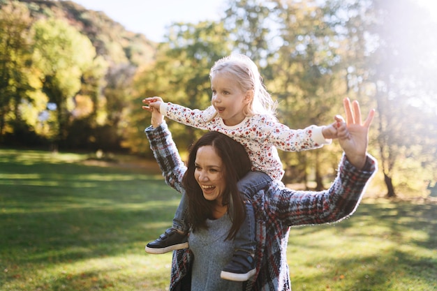 Mãe feliz com filha no parque outono recreação ao ar livre Mãe e filha