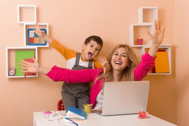 Mãe feliz com filho a trabalhar em casa