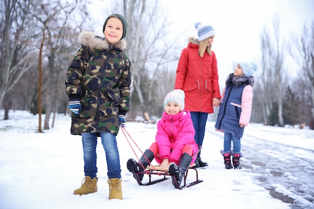 Mãe feliz com filhos em um parque nevado nas férias de inverno