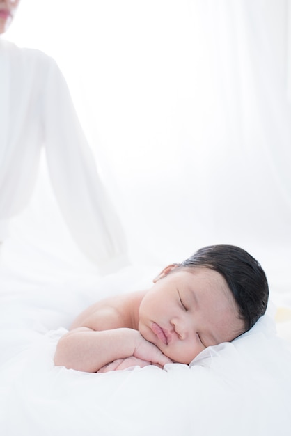 Mãe feliz com o bebê na cama