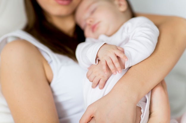 Mãe feliz com o bebê na cama