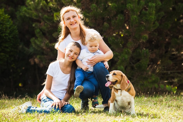 Mãe feliz com sua filha, filho pequeno e cachorro beagle para passear