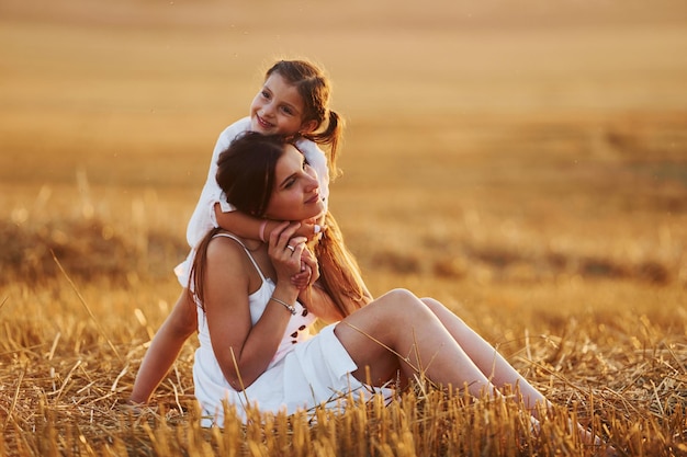 Mãe feliz com sua filha passando tempo juntos ao ar livre no campo