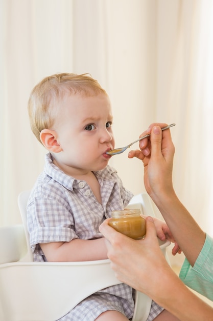 Mãe feliz comendo com seu bebê