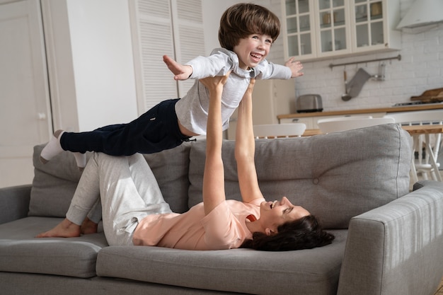 Mãe feliz e amorosa brincando com o filho fofo