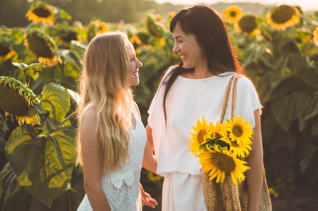 Mãe feliz e filha adolescente no campo de girassol