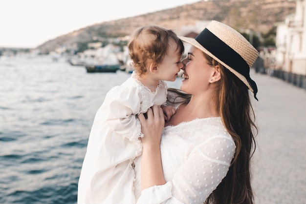 Mãe feliz e filha rindo sobre o mar