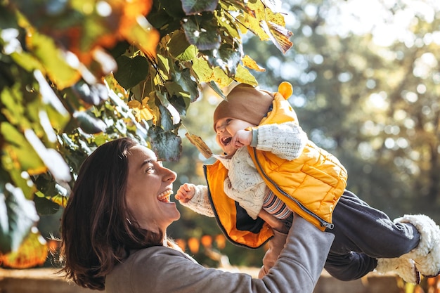 Mãe feliz e seu filho na natureza sorrindo brincando e abraçando Amor e ternura Dia internacional do abraço