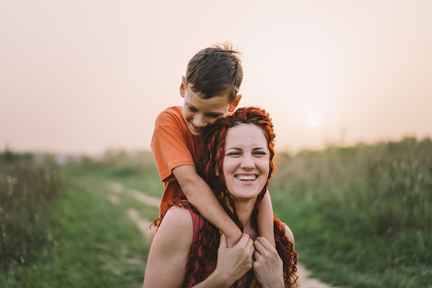 Mãe feliz se divertindo com seu filho ao ar livre Família e conceito de amor O conceito de relacionamentos do dia das mães com adolescentes cuidam e amam