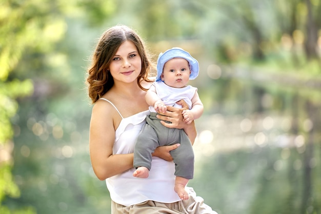 Mãe feliz segurando seu filho pequeno durante uma caminhada ao ar livre