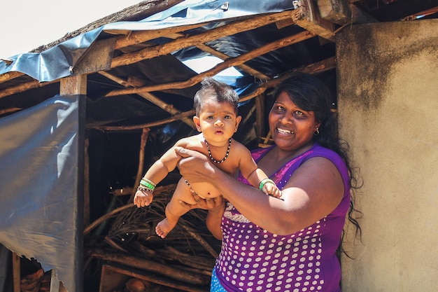 Mãe feliz segurando um bebê fofo recém-nascido em seus braços. Sri Lanka