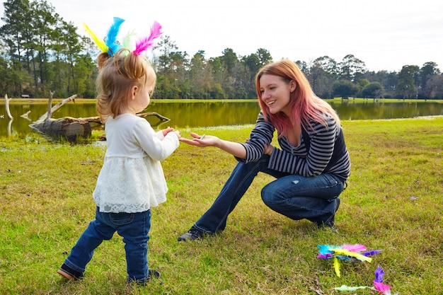 Mãe filha, tocando, com, penas, parque