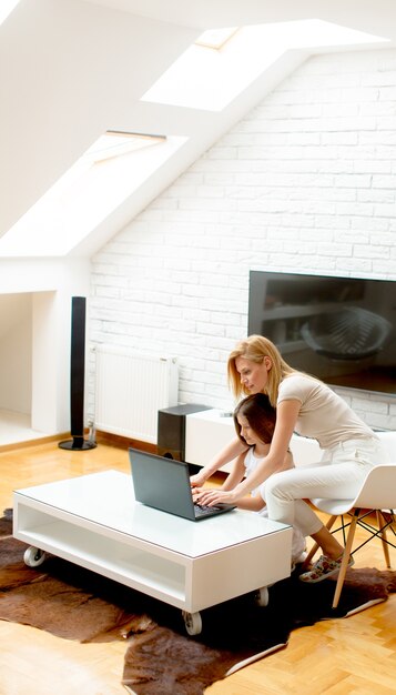 Foto mãe filha, usando computador portátil, casa