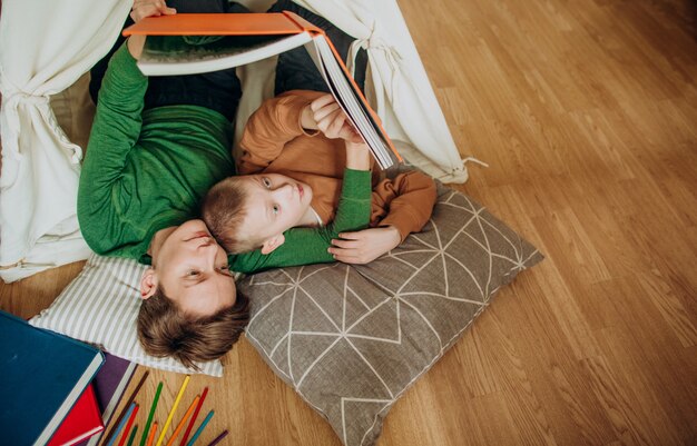 Mãe filho deitar juntos cabana ler livro