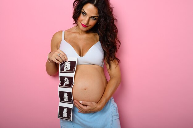 Mãe grávida mostra um ultrassom de seu filho