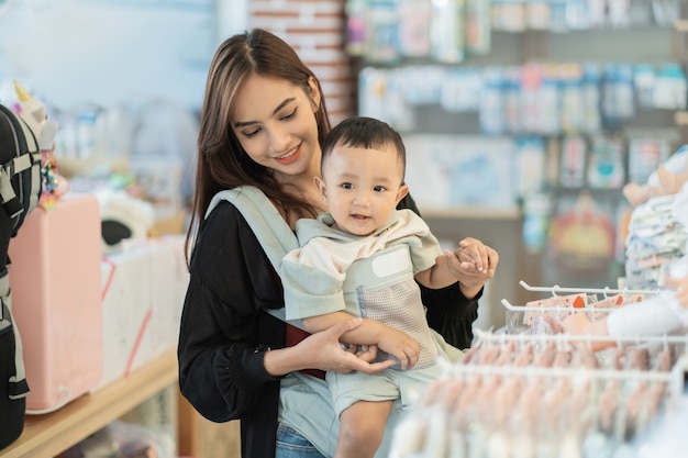 Mãe indonésia comprando roupas para o filho na boutique de bebês