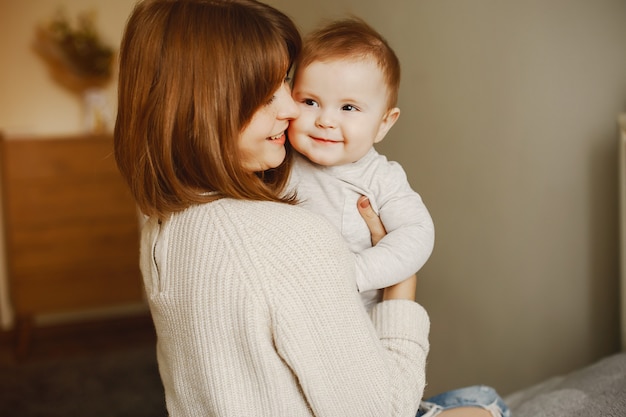 mãe jovem e bonita, brincando com seu filho em casa