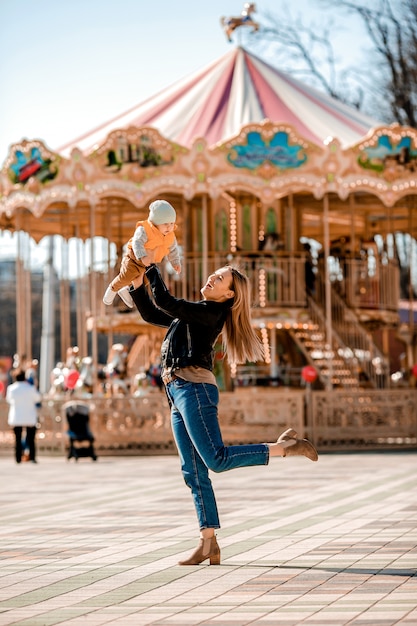 Mãe jovem elegante caminha com o bebê no parque. mãe feliz