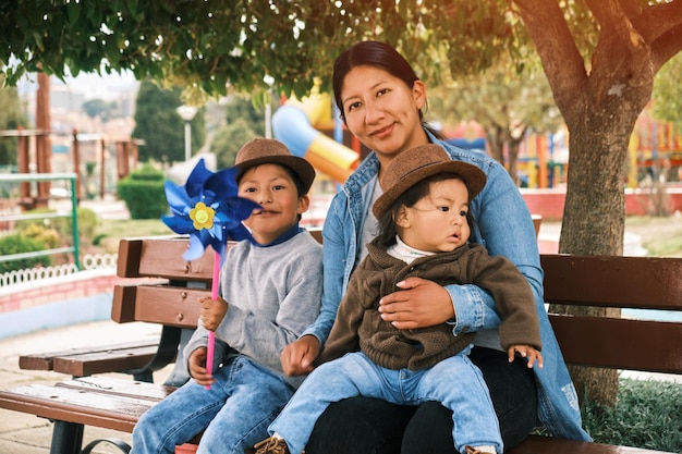Foto mãe latina feliz e seus dois filhos passeando em um parque público na bolívia américa latina